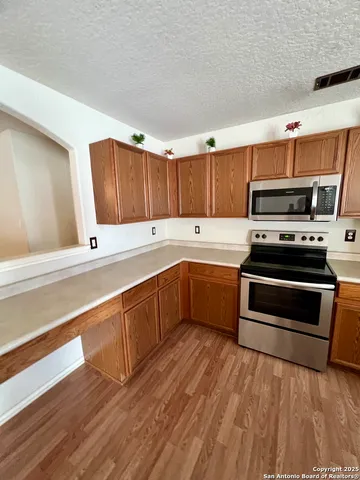 a kitchen with wooden cabinets and stainless steel appliances