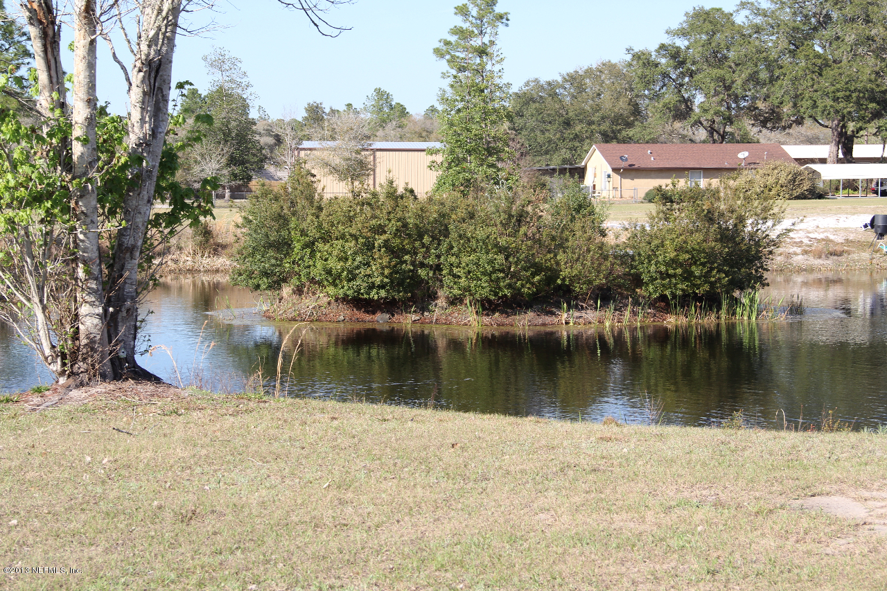 1999-2001 Ryan Road St. Augustine, FL 32092 - Photo 6 of 48 a view of a lake with a yard and large trees