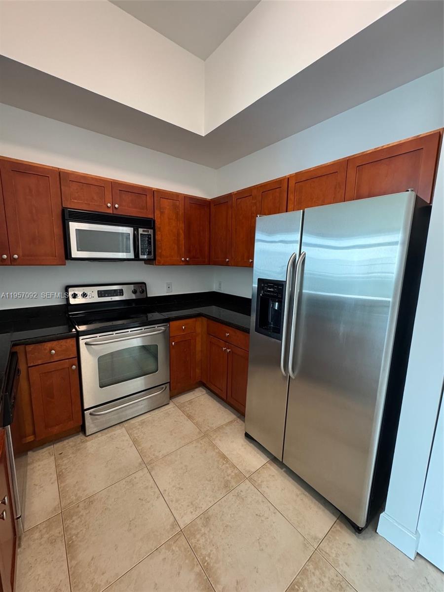 1723 Southwest 2nd Avenue, Unit P08 Miami, FL 33129 - Photo 5 of 21 a kitchen with granite countertop a refrigerator and a stove