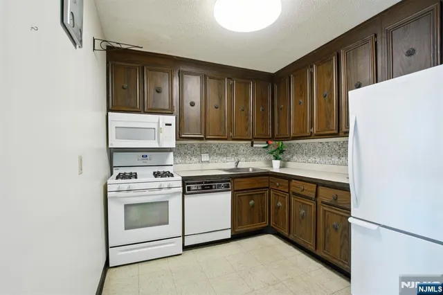 a kitchen with stainless steel appliances granite countertop a stove sink and cabinets