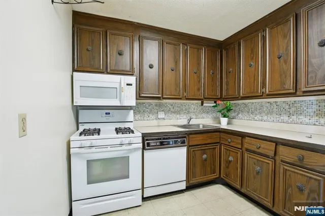 a kitchen with stainless steel appliances granite countertop a stove microwave and cabinets