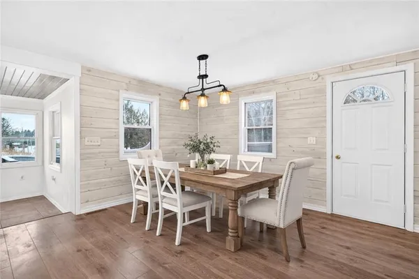 a dining room with furniture a chandelier and wooden floor