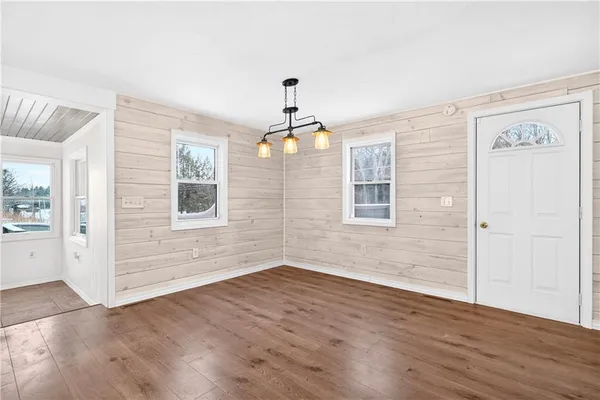 a view of a kitchen with wooden floor electronic appliances and windows