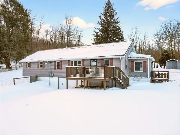 a view of a white house with a large trees and a big yard