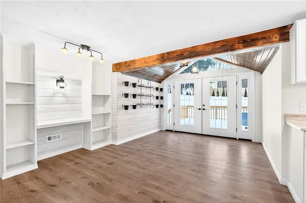 a view of a porch with wooden floor and white walls