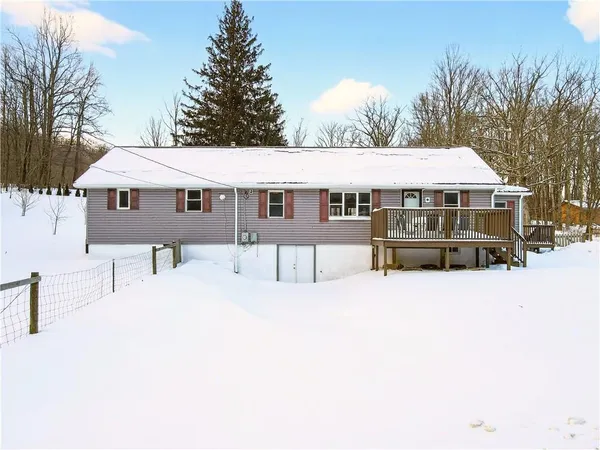 a view of house with yard and trees in the background