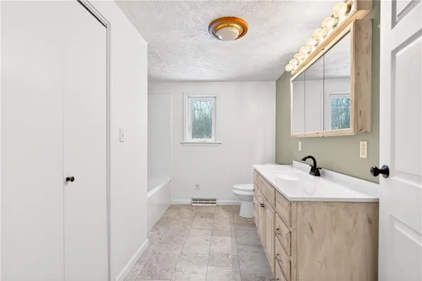 a bathroom with a bathtub a shower a toilet and a window