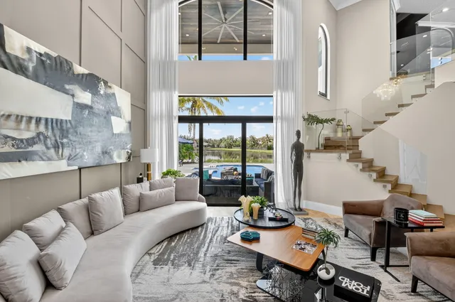 a view of a dining room with furniture large window chandelier and wooden floor