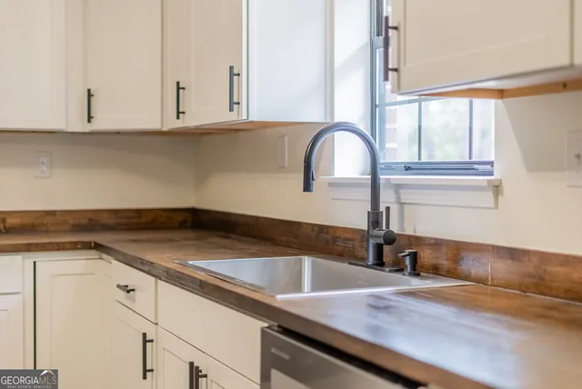 a view of a kitchen sink with cabinets