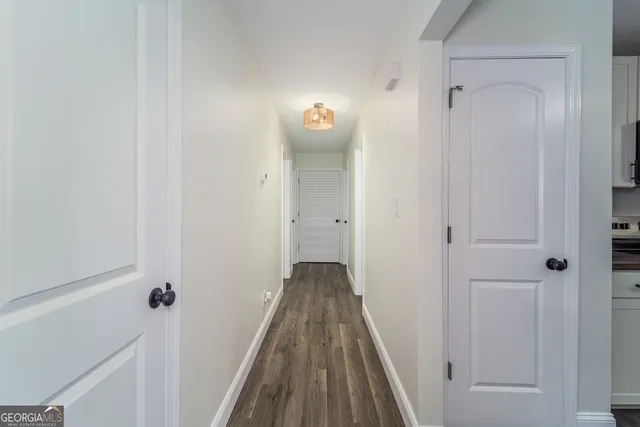 a view of a hallway with wooden floor and staircase