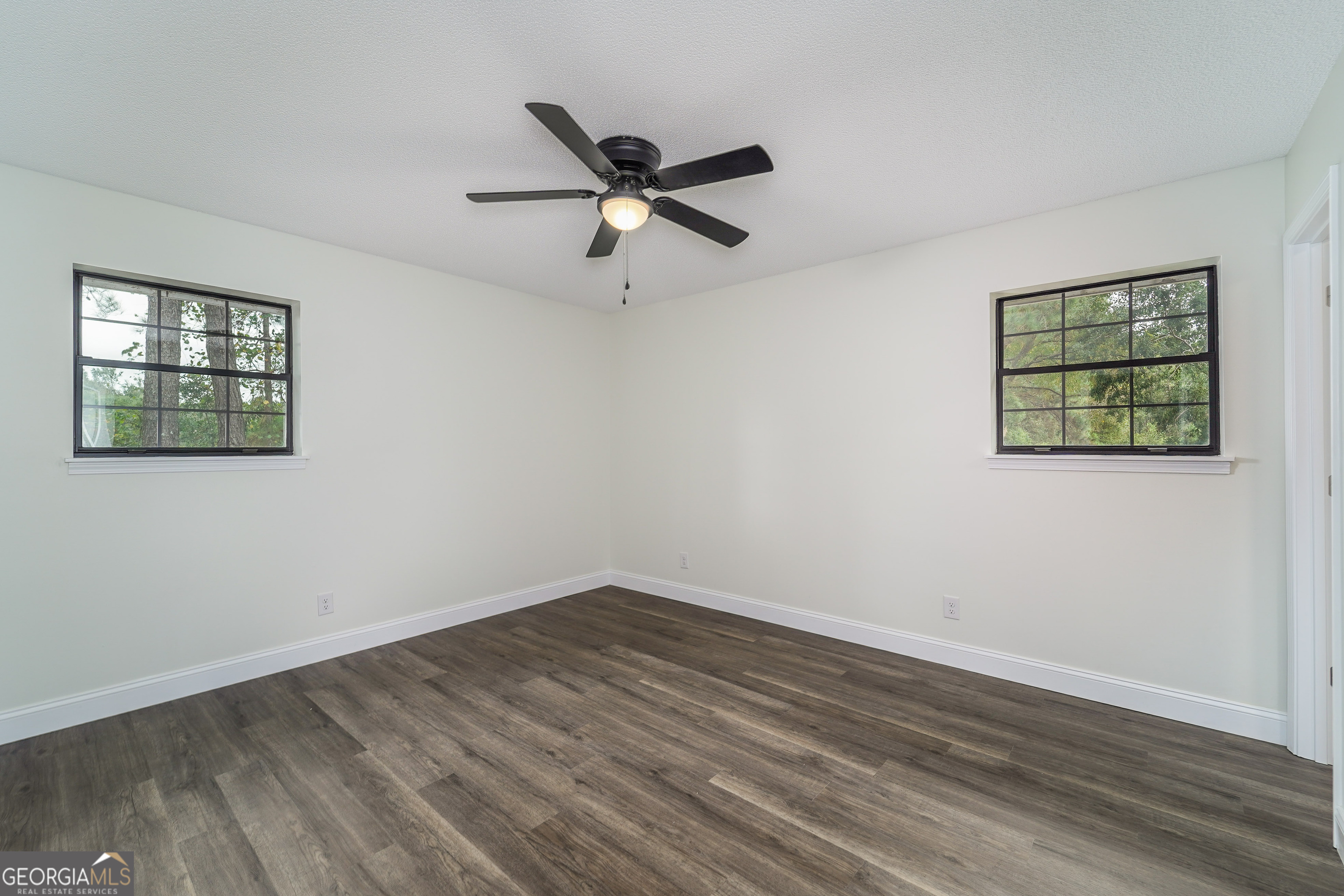 5406 Blue Spruce Road Blackshear, GA 31516 - Photo 18 of 28 a view of empty room with wooden floor and fan
