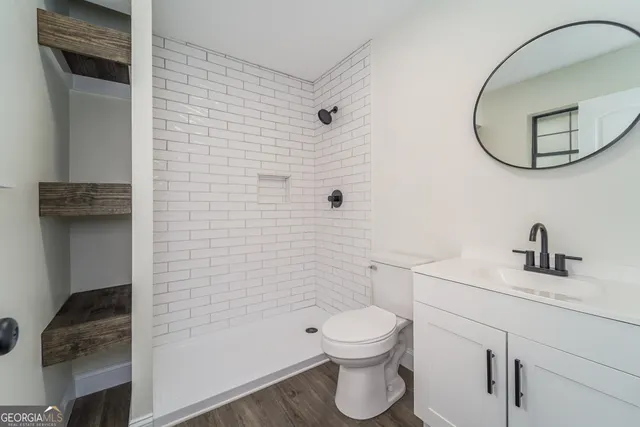 a bathroom with a toilet a sink a shower and mirror