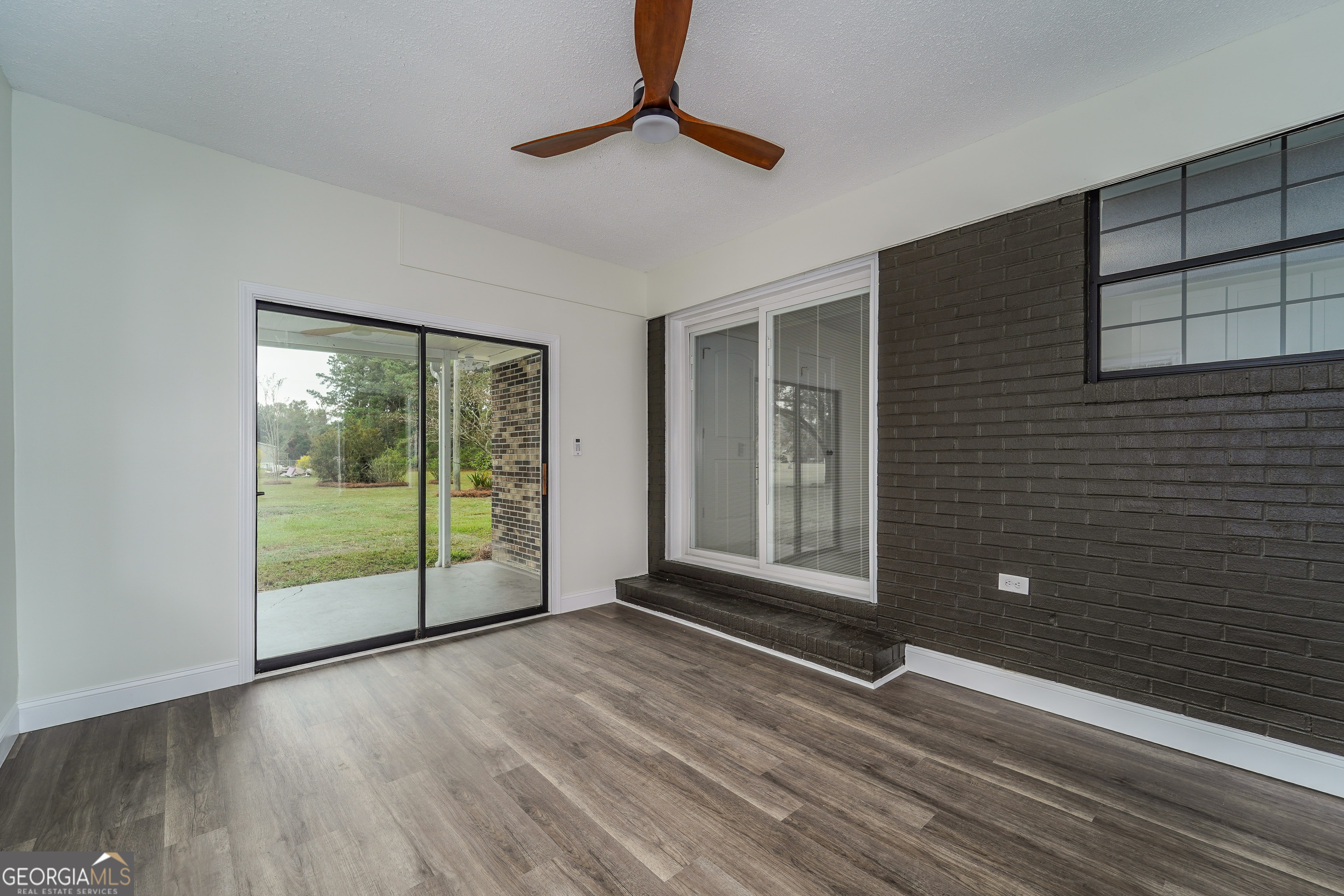 5406 Blue Spruce Road Blackshear, GA 31516 - Photo 26 of 28 a view of empty room with floor to ceiling window and wooden floor
