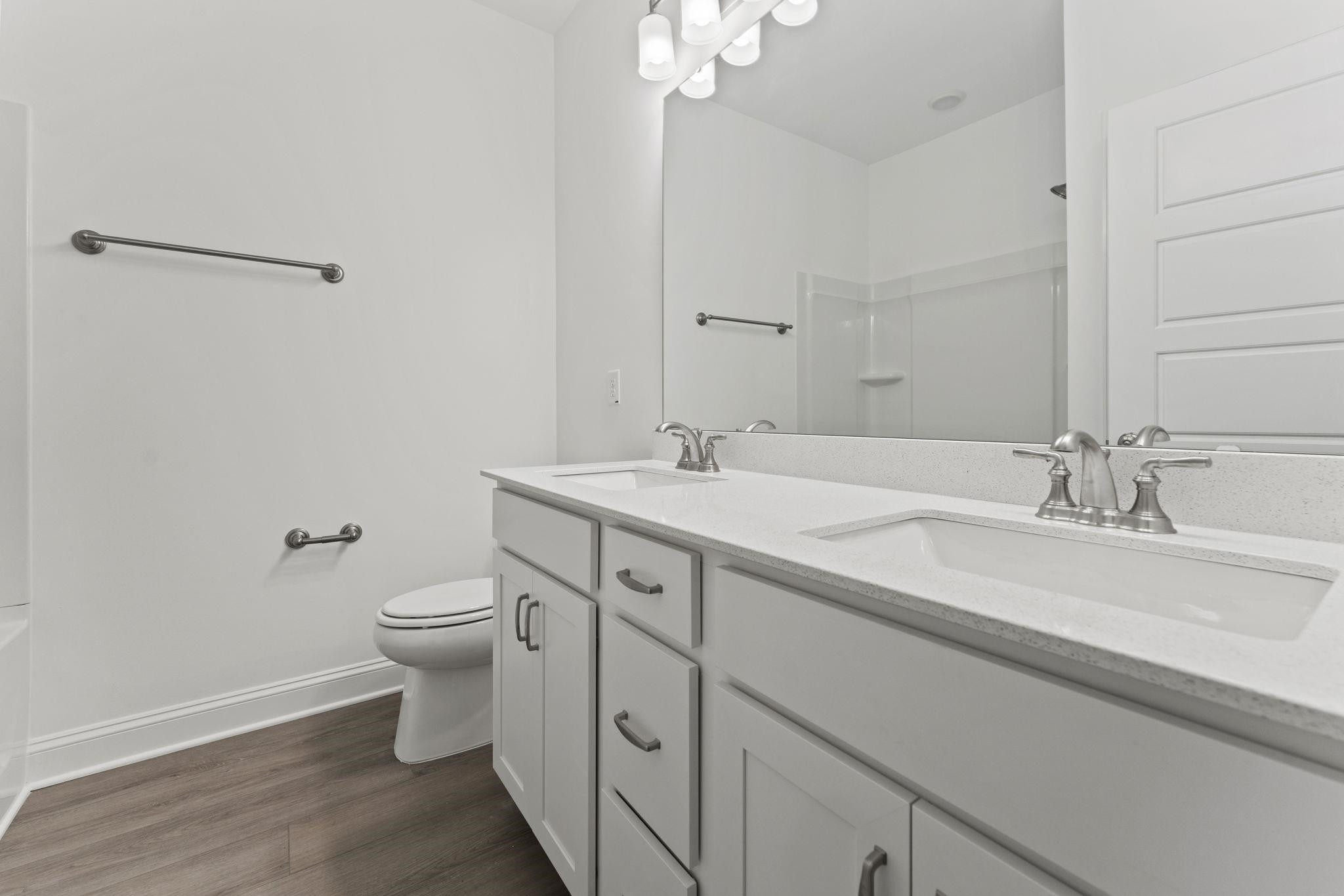 2128 Voekler Street Apex, NC 27502 - Photo 12 of 27 a bathroom with a sink a toilet and a mirror