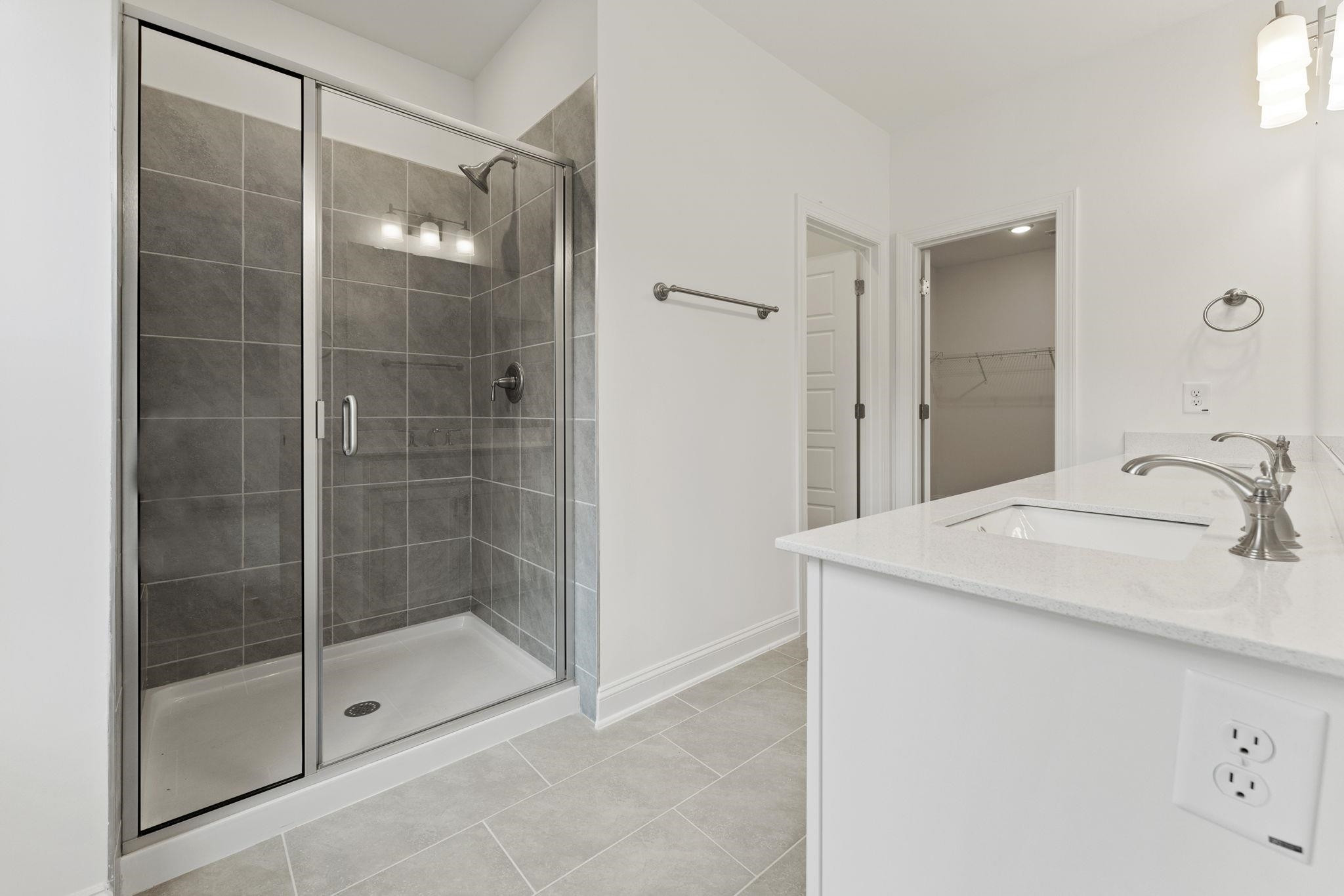 2128 Voekler Street Apex, NC 27502 - Photo 15 of 27 a bathroom with a shower sink and mirror