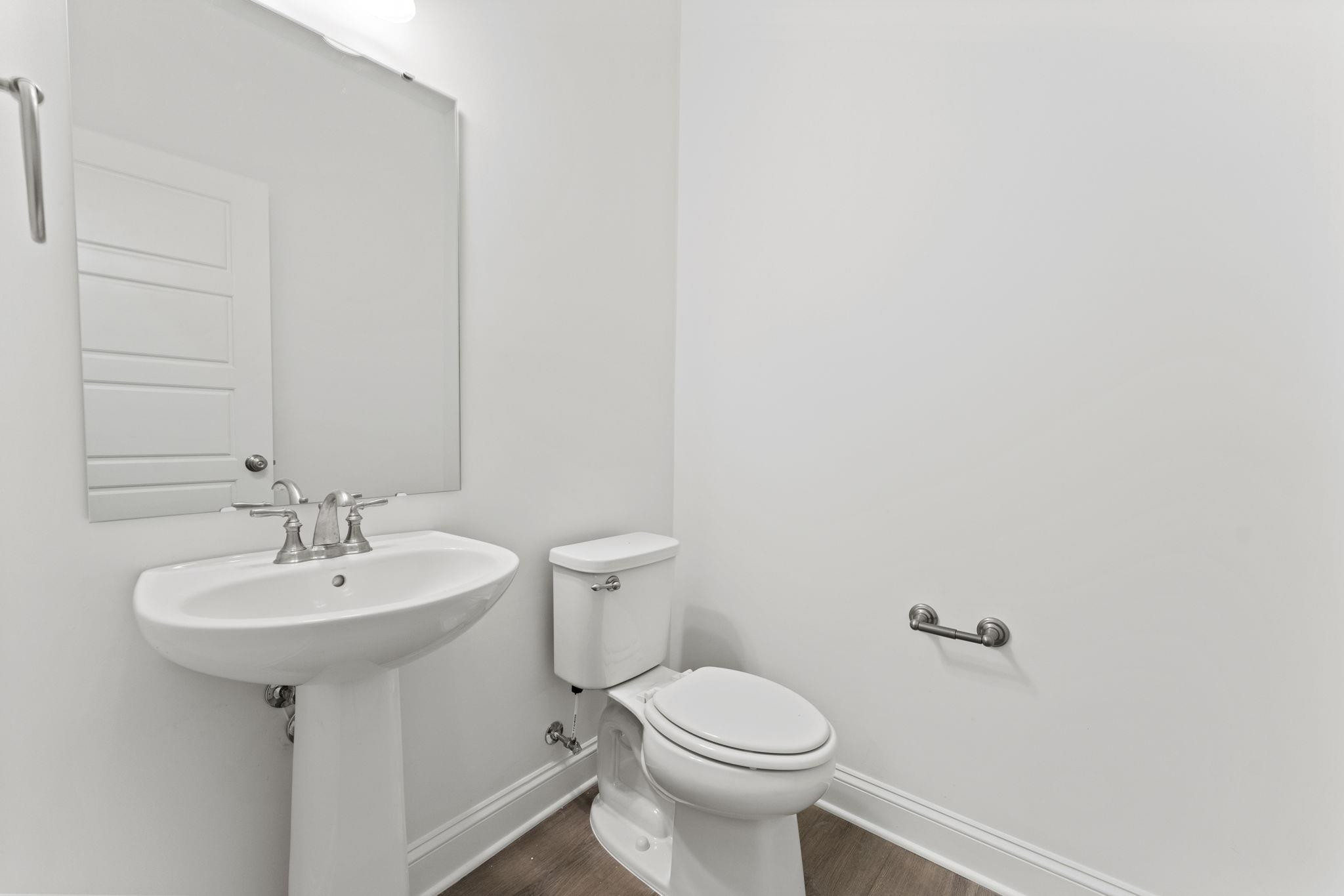 2128 Voekler Street Apex, NC 27502 - Photo 3 of 27 a bathroom with a sink a mirror and a toilet