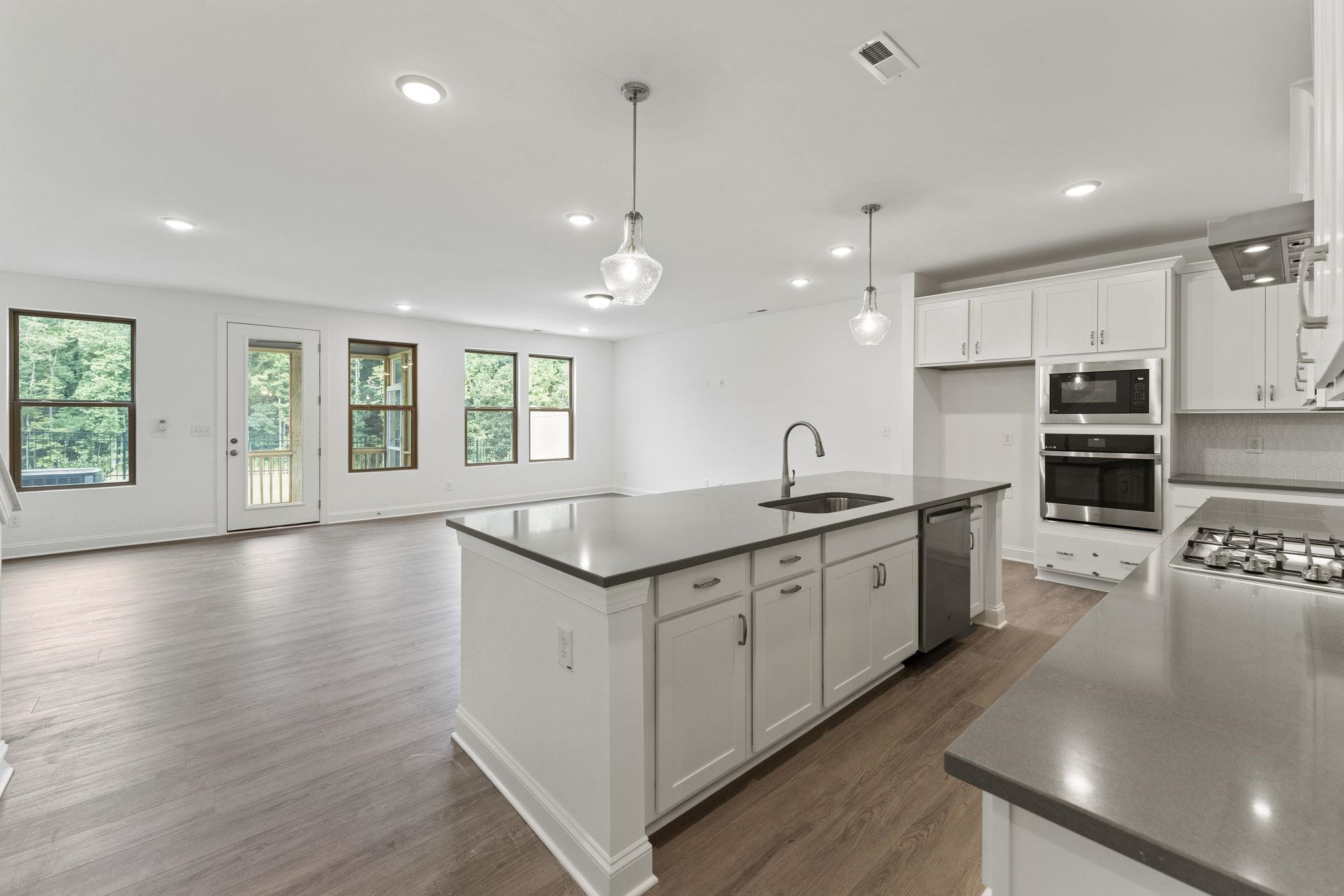 2128 Voekler Street Apex, NC 27502 - Photo 4 of 27 a large kitchen with stainless steel appliances granite countertop a lot of counter space and wooden floor