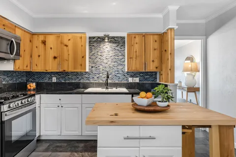 a kitchen with stainless steel appliances granite countertop a sink a stove and cabinets