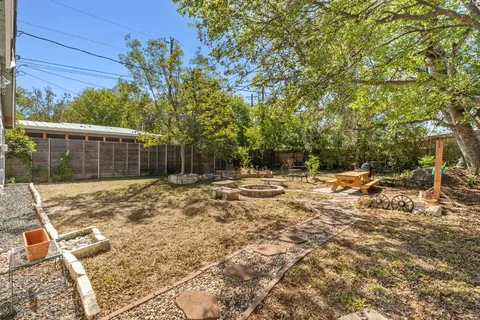 a backyard of a house with table and chairs