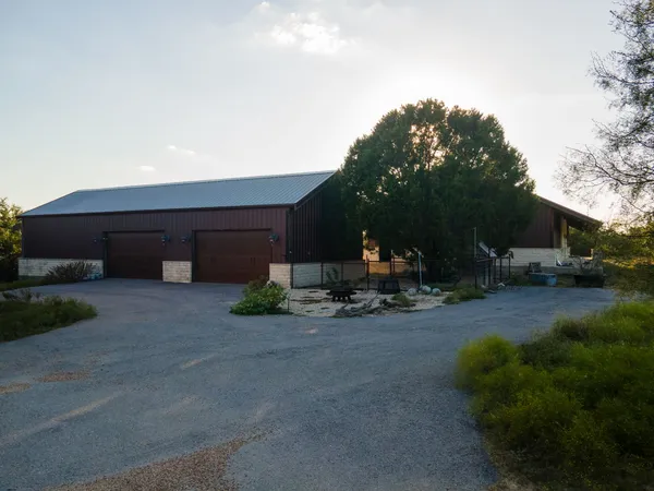 a view of a house with backyard and parking area
