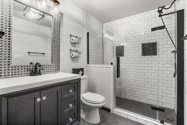 a bathroom with a sink a toilet and shower