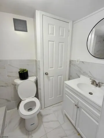 a bathroom with a toilet a sink and a mirror