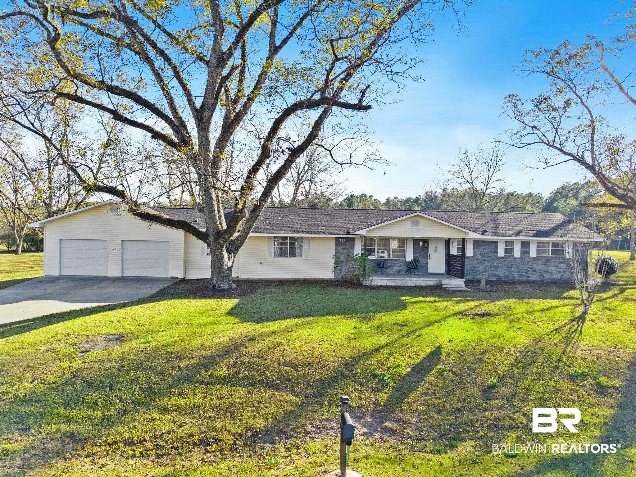 Ranch-style house featuring covered porch, a front yard, and asphalt driveway