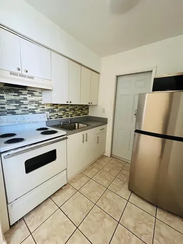 a kitchen with a white cabinets and white appliances