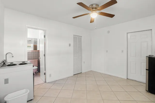 a view of an empty room with a window and a ceiling fan