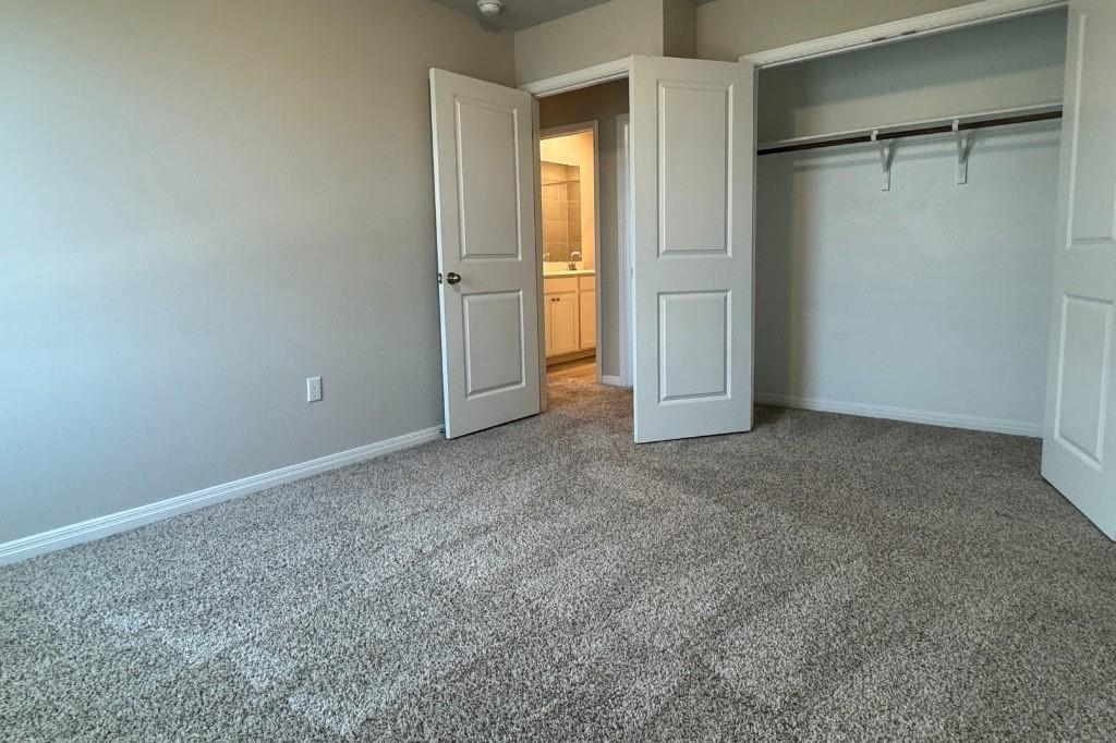 12604 Dairywork Road Buda, TX 78610 - Photo 17 of 20 Comfortable carpet flooring creates a serene atmosphere, with a clear view into an adjacent bathroom.
