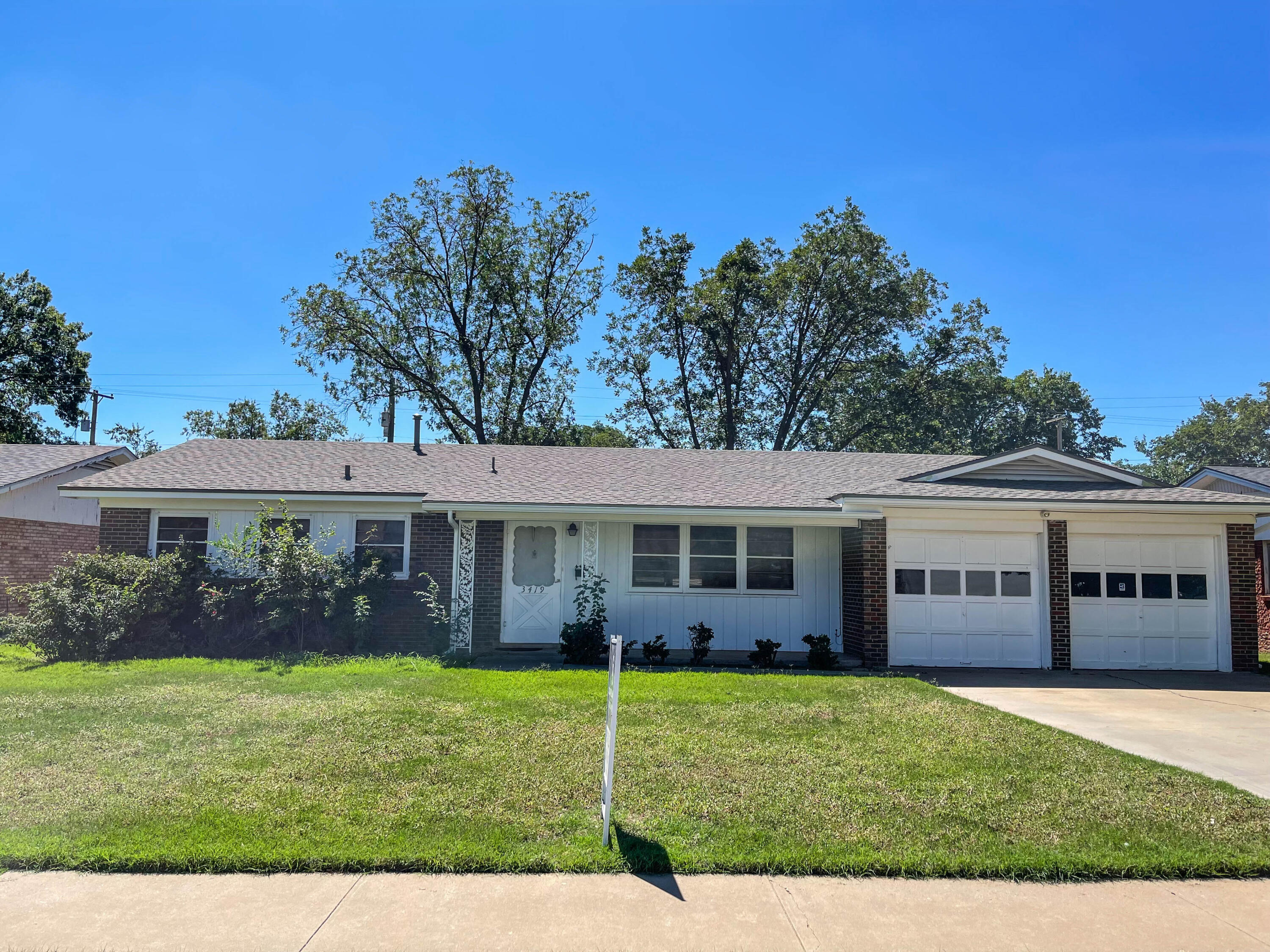 a view of a house with a yard and potted plants