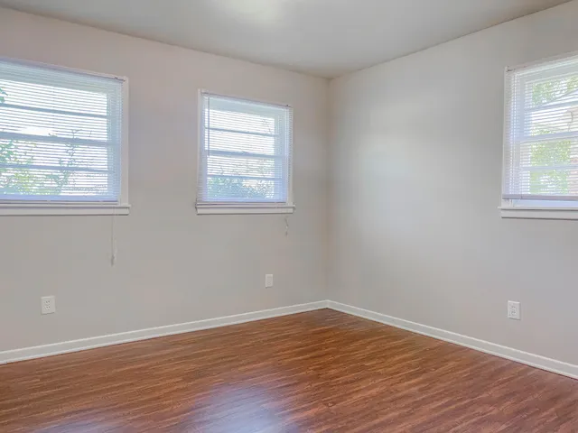 a view of a room with wooden floor and windows