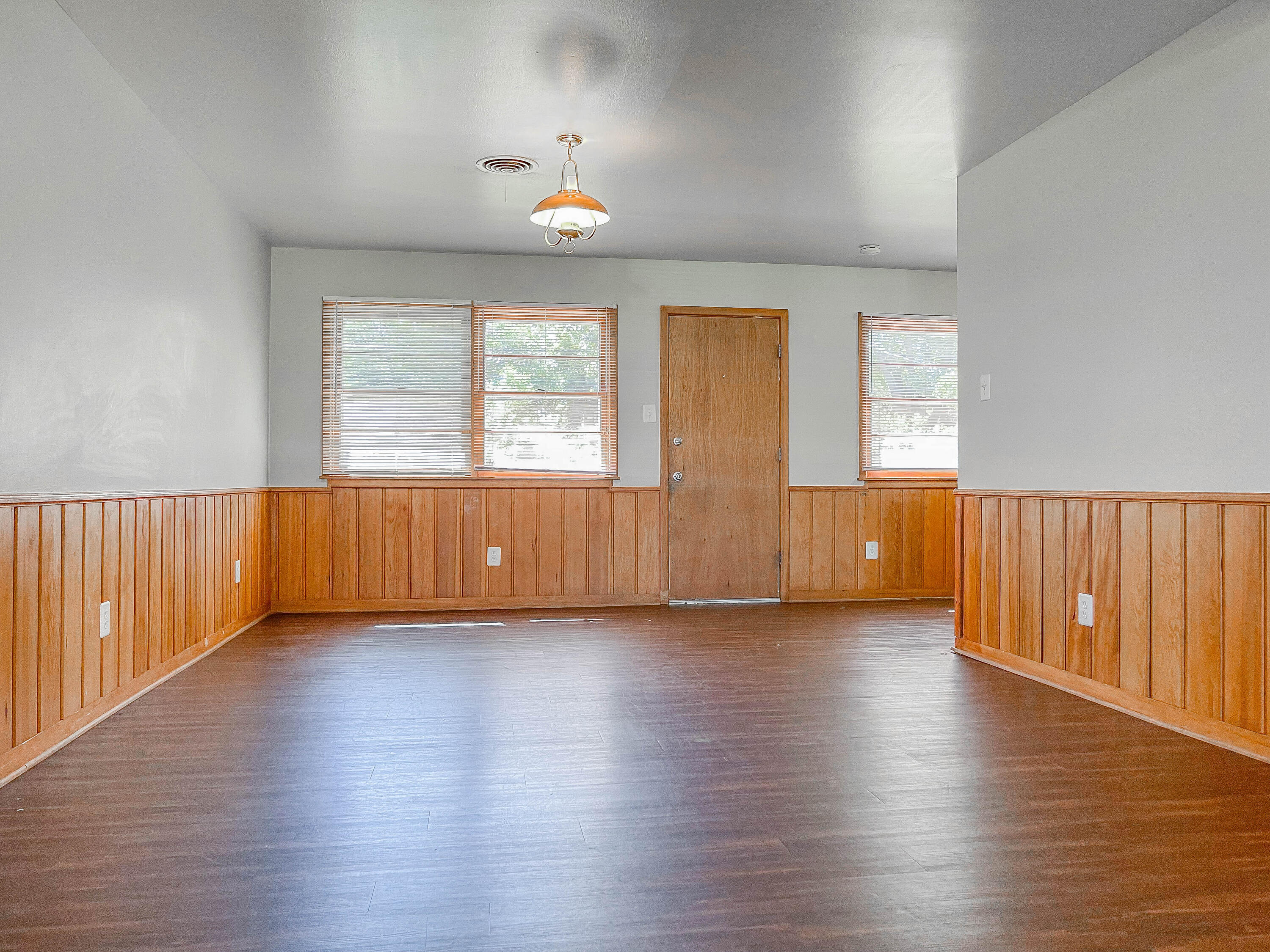 3419 53rd Street Lubbock, TX 79413 - Photo 3 of 11 an empty room with wooden floor and windows
