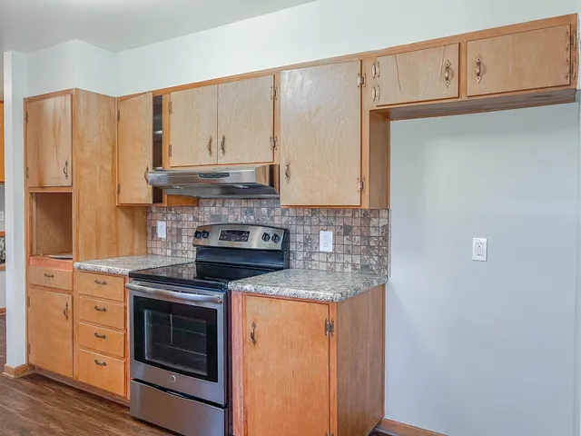 a kitchen with granite countertop cabinets stainless steel appliances and a counter space