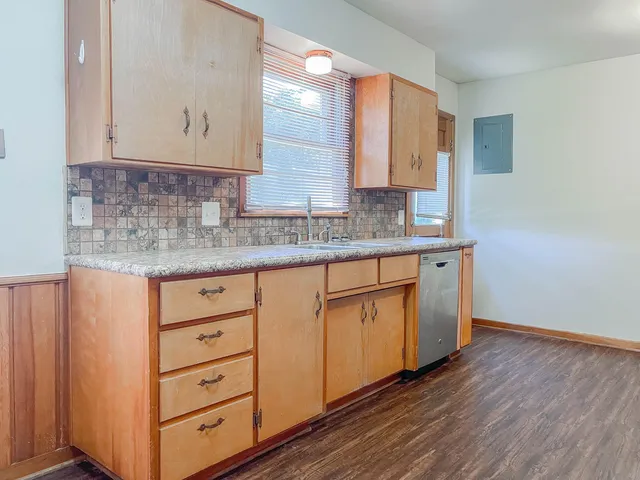 a kitchen with cabinets appliances and a wooden floor
