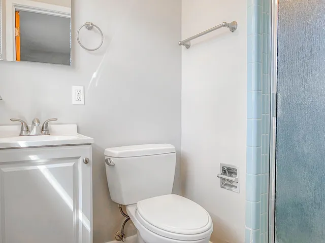 a bathroom with a toilet a sink and mirror