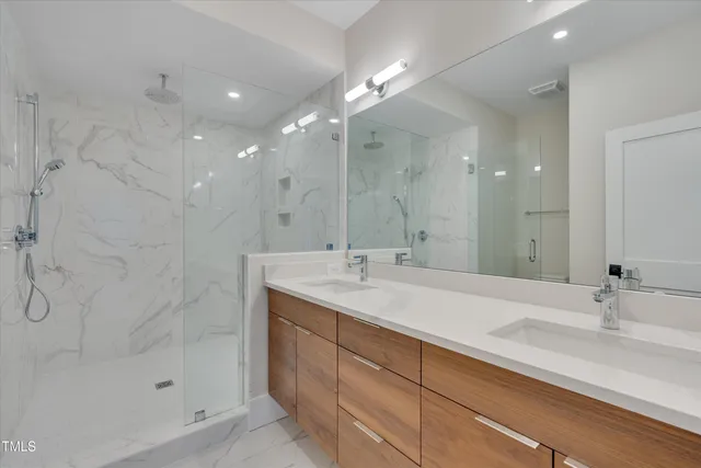 a bathroom with a sink shower and a mirror