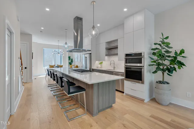 a kitchen with stainless steel appliances a kitchen island a stove a table and chairs