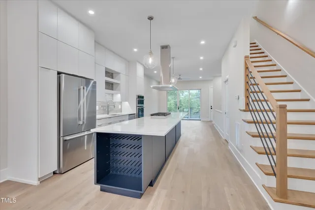 a large kitchen with kitchen island white cabinets and stainless steel appliances