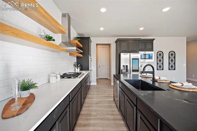a kitchen with stainless steel appliances granite countertop a sink and a stove top oven
