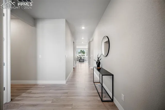a view of a hallway with wooden floor and staircase