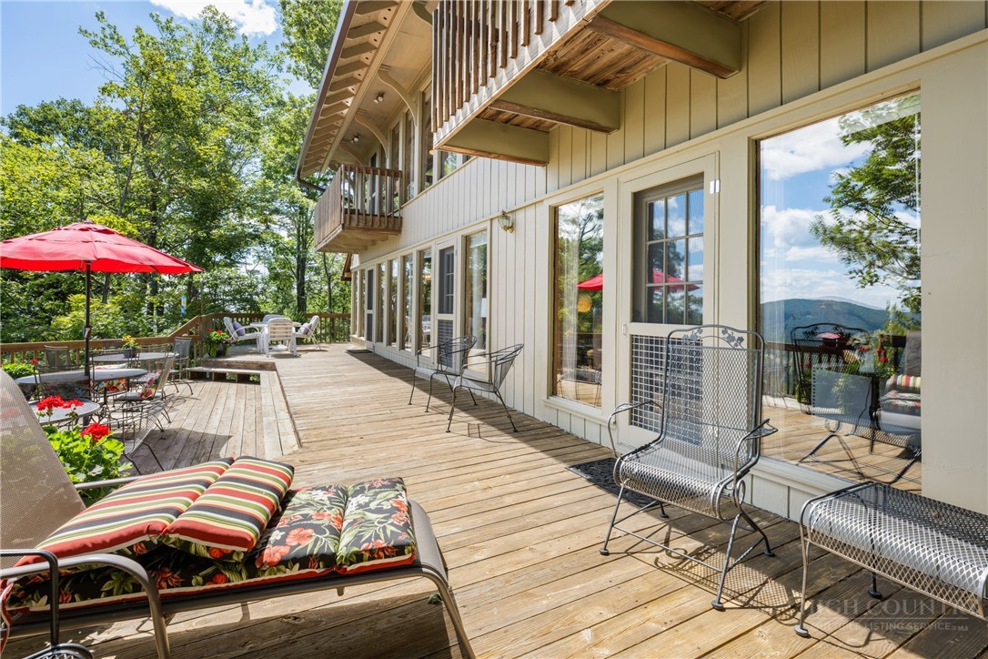 2177 Homestead Road Todd, NC 28684 - Photo 29 of 49 a view of a patio with couches and table and chairs under an umbrella