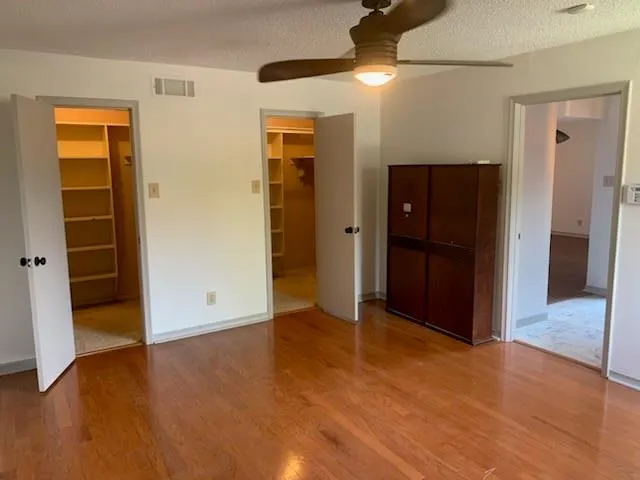 an empty room with closet and wooden floor