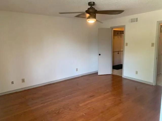 an empty room with a ceiling fan and chandelier fan
