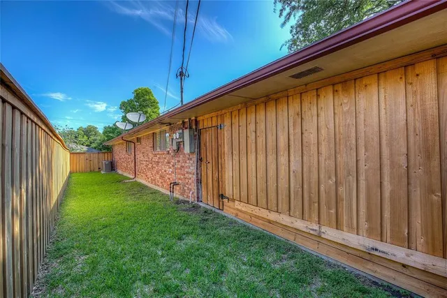 a view of a backyard with wooden fence and plants
