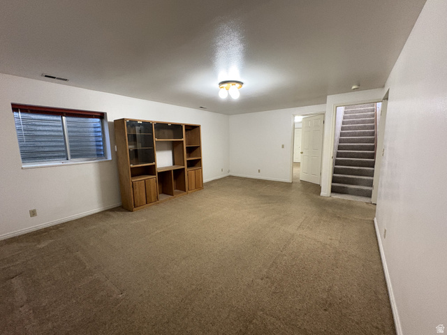 486 West 120 North Orem, UT 84057 - Photo 16 of 30 Carpeted room with white walls and a built-in wood-finish storage unit