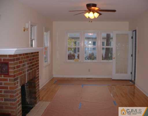 889 Englishtown Road Old Bridge, NJ 08857 - Photo 4 of 8 a view of an empty room with window and wooden floor