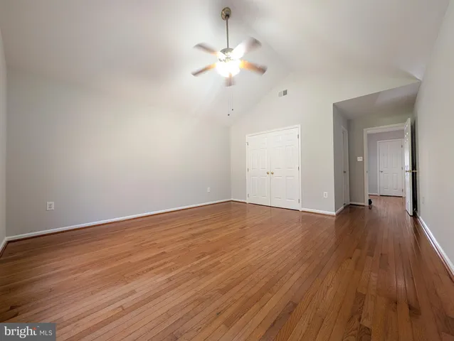 a view of a room with wooden floor and a ceiling fan