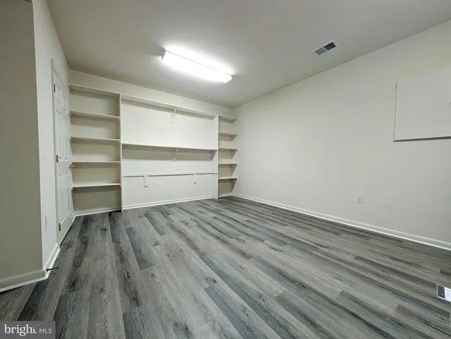 a room with walk in closet and wooden floor