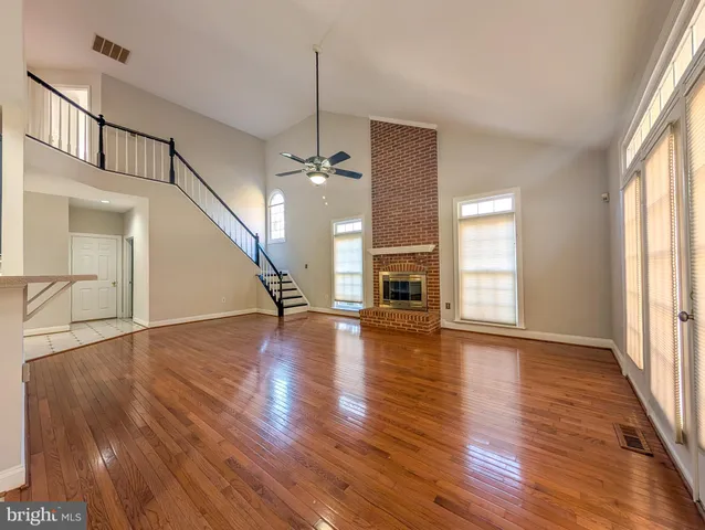a view of empty room with wooden floor and fireplace